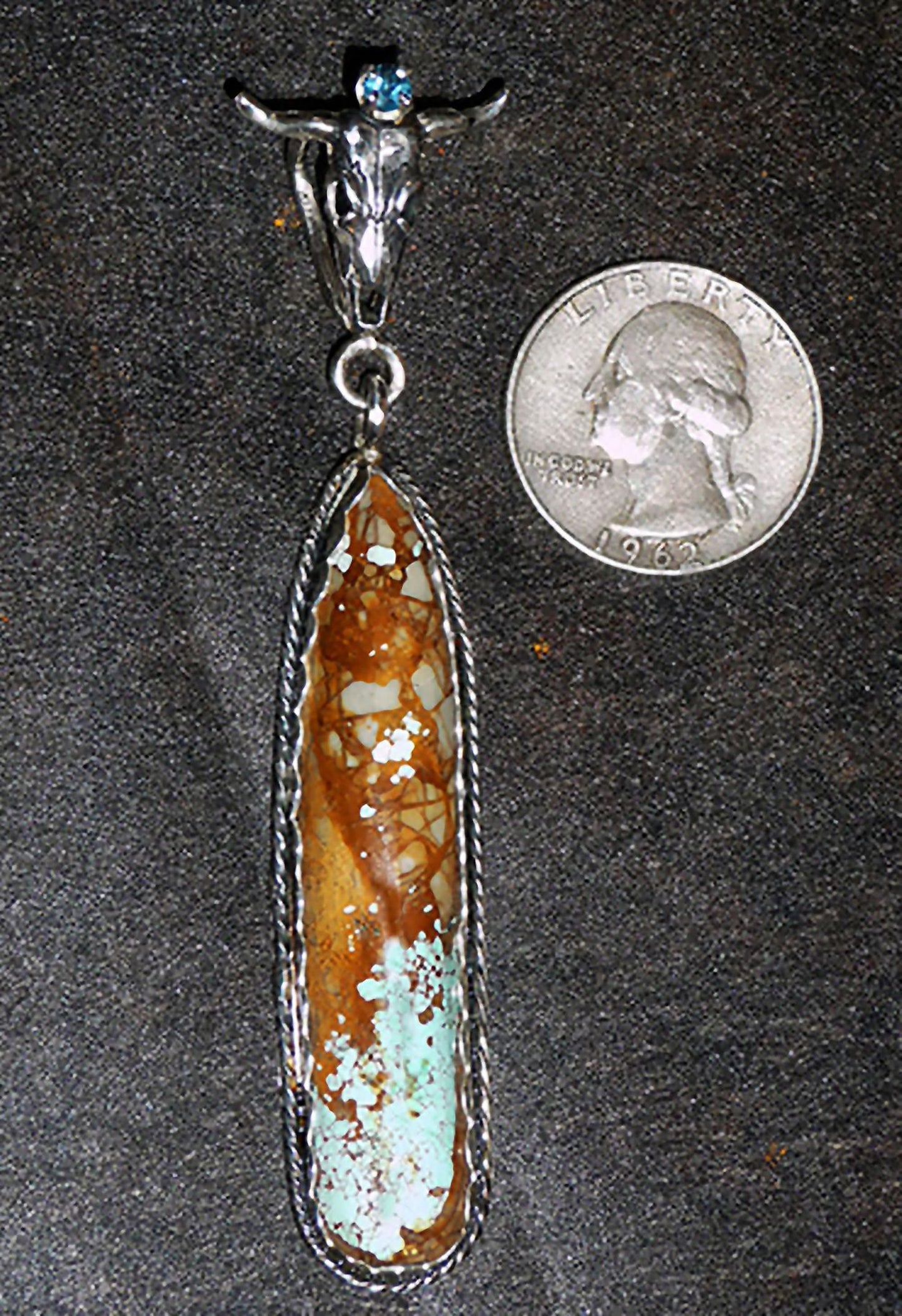 Take the bull by the horns and pick this stunning natural Nevada Turquoise stone with a blue topaz, mounted in Sterling Silver.