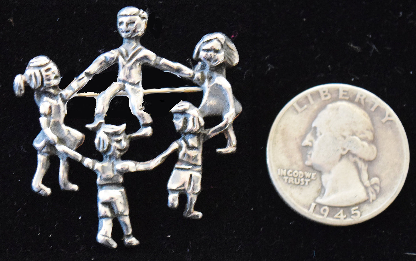 Vintage pin in sterling silver with children playing.