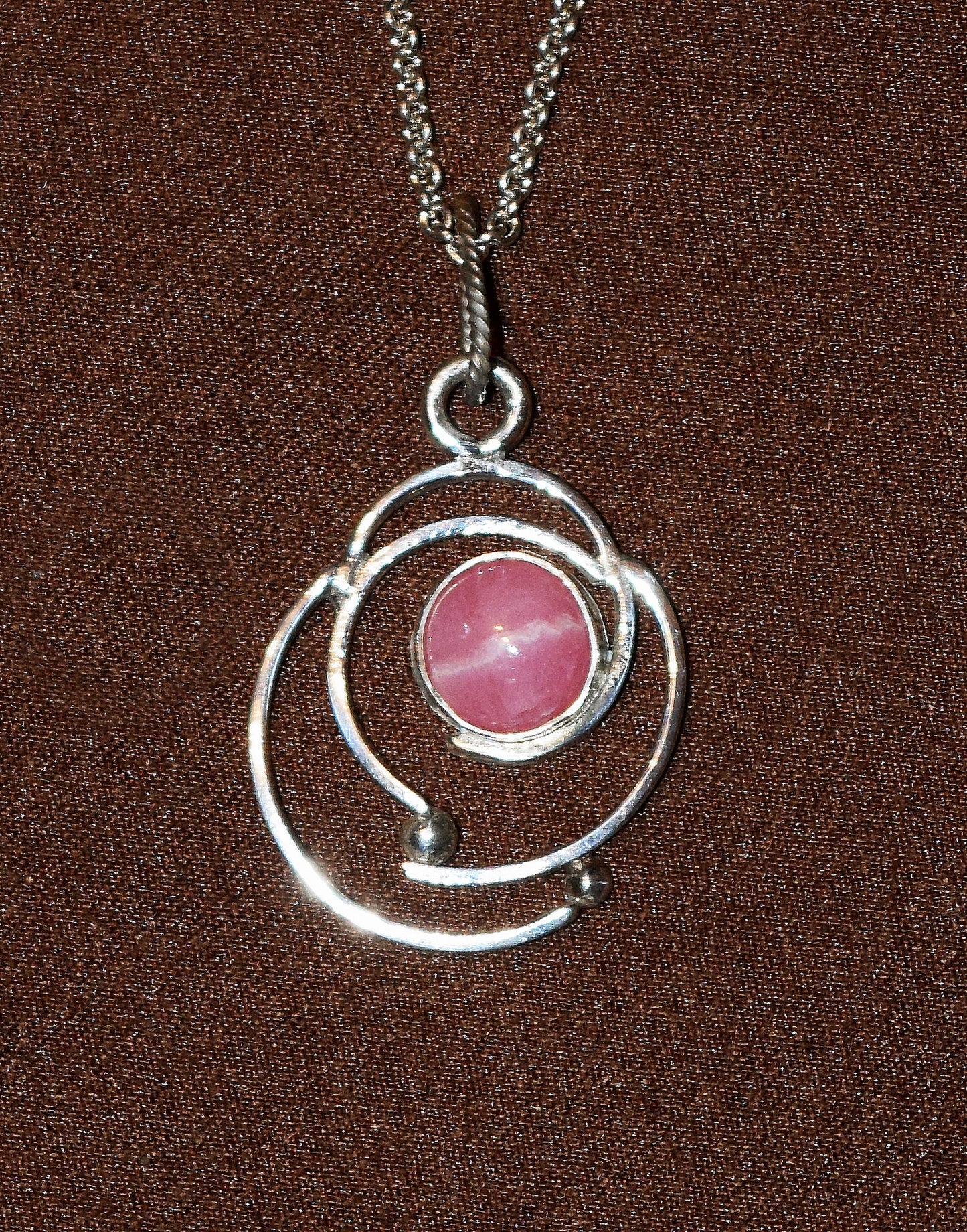 Handcrafted Sterling Silver pendant featuring a Rhodochrosite gemstone. Includes a 18-inch Sterling necklace.
