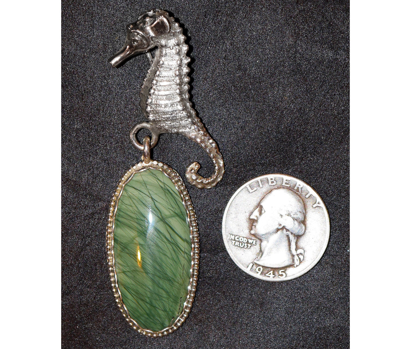 A serene seahorse hovers near what looks like seagrass captured in a stone. Featuring rare  ?Mexican Imperial Jasper?.